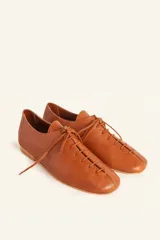 Zapato tipo oxford plano de cuero vacuno en color azul marino, con cordones al tono y suela de cuero.