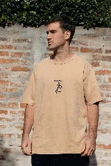 Remera color arena de manga corta con cuello redondo y estampado minimalista en el centro del pecho.