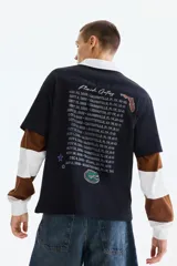 Remera de algodón negro con hombros caídos y cuello redondo. Estampado frontal estilo universitario con la inscripción 'Gators', casco de fútbol americano e insignias conmemorativas.