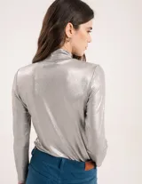 Polera dorada de cuello alto y manga larga, confeccionada en tejido elastizado con terminación metalizada.