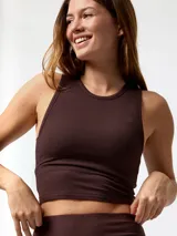 Remera sin mangas de corte crop y diseño ajustado, confeccionada en tejido rib con baño de Aloe Vera. Cuenta con top integrado, cuello redondo y detalle de logo bordado en el pecho.