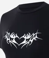 Remera de algodón con elastano, de corte ajustado, manga corta y cuello redondo. Presenta una estampa frontal de corazón con diseño tribal en color blanco sobre fondo negro.