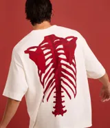 Remera overboxy blanca de manga corta y cuello redondo, con estampa grande de un esqueleto rojo en la espalda.