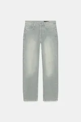 Jeans de tiro bajo y corte recto, confeccionados en denim con estampado de rayas verticales y efecto lavado. Presenta cinco bolsillos, trabillas en la cintura, cierre frontal con cremallera y botón, y un detalle de rotura en la parte delantera.