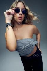 Top strapless de jean gris claro, ajustado al cuerpo, con detalle de doble tira con hebillas metálicas en la parte delantera.