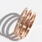 Anillo triple color oro rosa de acero con cristales incrustados de circonita cúbica.
