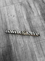 Cinto con estampado de cebra y hebilla redonda dorada.