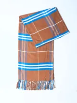 Bufanda tipo pashmina color marrón con diseño a cuadros en azul, blanco y gris.
