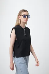 Remera sin mangas negra con hombros marcados y caída recta.