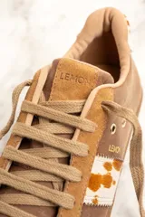 Zapatillas bajas color marrón con detalles en cuero con estampado de vaca en los laterales y talón.