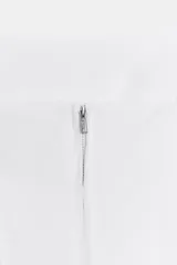 Top crop corsetero negro de popelín con escote recto, tirantes finos ajustables con lazada y bajo acabado con volante. Tiene forro interior a tono y cierre de cremallera en la espalda.