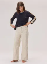 Pantalon de corte recto con costuras verticales decorativas en contraste color rojo. Presenta cintura con trabillas, cierre frontal con botón y bolsillos laterales.