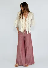 Pantalón de lino color ladrillo, de corte palazzo y tiro alto, con bolsillos laterales y cordón ajustable en la cintura.