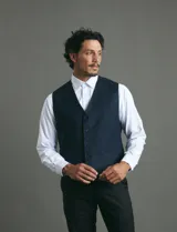 Chaleco de vestir color azul oscuro con textura sutil, corte clásico, cierre frontal con botones y bolsillos laterales simulados.