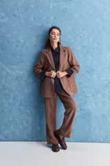 Blazer de corte sastrero con silueta relajada, solapas tradicionales, cierre frontal de un botón y bolsillos de vivo.
