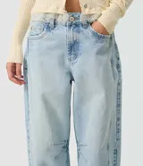 Pantalón de jean con corte balloon, tiro alto y lavado claro, confeccionado en algodón. Presenta piernas amplias con ruedo levemente entallado, bolsillos delanteros y traseros, pasadores para cinturón y cierre frontal con botón y cremallera.