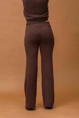 Conjunto de dos piezas tejido en color marrón chocolate, compuesto por un buzo de cuello alto con bolsillos frontales y un pantalón de corte recto y holgado.