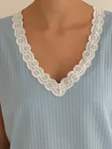 Pijama celeste de algodón acanalado compuesto por una remera de manga corta con escote en V adornado con puntilla blanca, y un short a juego con elástico y lazo de ajuste en la cintura.