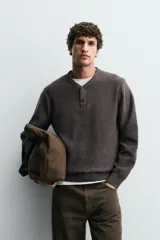 Jersey de punto de algodón con corte relajado, cuello en pico con cierre frontal de botones y manga larga con puños y bajo en rib.