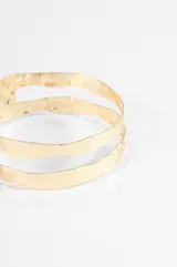 Brazalete rígido de diseño abierto con doble banda, acabado plateado y textura martillada.