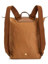 Mochila Longchamp modelo Le Pliage Original en tamaño M, color marrón. Presenta un diseño minimalista con correas ajustables de tela, detalles en cuero en la parte superior y cierre principal. Incluye un pequeño botón metálico en la parte inferior.