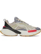 Championes Under Armour modelo UA Arc 96, con diseño futurista de inspiración retro. Capellada de malla múltiple en tono beige con superposiciones de cuero y paneles laterales translúcidos. Incorpora detalles en gris, negro y un toque de rojo, con entresuela voluminosa y suela de goma color caramelo.