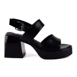Sandalias negras de cuero sintético con plataforma y taco cuadrado. Tiras anchas sobre el empeine y tobillo con hebilla ajustable.