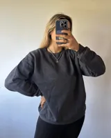 Buzo gris oscuro de corte clásico, confeccionado en 50% algodón y 50% poliéster con felpa en el interior.