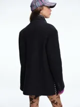 Chaqueta de silueta estructurada con hombreras, solapas clásicas y cierre frontal con botones. Confeccionada en lana con forro de poliéster.