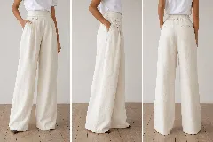 Pantalón de corte amplio y tiro alto, confeccionado en lino natural. Presenta una pretina estructurada, tablas frontales que aportan movimiento y un detalle de mini bolsillo lateral con tapa y botón. Diseño de líneas limpias con bolsillos laterales y traseros.