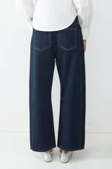 Jeans de tiro medio con corte barrel y ajuste relajado, diseño clásico de cinco bolsillos, cierre frontal de cremallera y botón metálico.