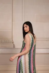 Vestido largo de tejido de punto con estampado de zig-zag vertical en tonos rosados, verdes, beige y lila. Presenta escote en V pronunciado tanto en el frente como en la espalda, con vivos de punto con lurex.