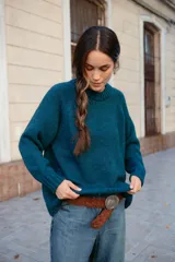 Buzo de lana color rosado, con cuello redondo, mangas largas y diseño holgado.