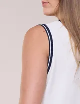 Musculosa de tejido de punto color azul marino, de corte recto, con cuello redondo y sisa amplia. Presenta detalles de líneas en contraste de color blanco en el cuello, las sisas y el ruedo.