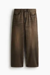 Jeans de corte relajado y pierna recta, confeccionados en denim de algodón rígido en color marrón con efecto desteñido y lavado desgastado. Presentan diseño clásico de cinco bolsillos, trabillas para cinturón y cierre frontal con botón y cremallera.