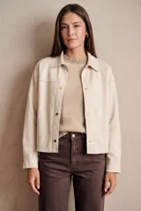 Camisa tipo sobrecamisa oversize color crudo, confeccionada en tejido de gamuza vegana con cierre frontal de botones metálicos y cuello clásico.