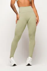 Calza deportiva de tiro alto color verde claro, con costuras laterales en contraste de color blanco que recorren la prenda desde la cintura hasta los tobillos.