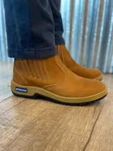 Botín marrón de cuero con elásticos laterales, suela de goma color caramelo y puntera reforzada.