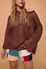 Sweater verde oliva de lino tejido a mano con diseño de trenzas. Tiene silueta oversize, mangas rectas y cuello redondo.