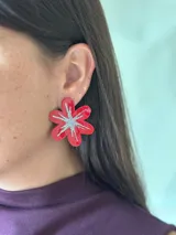 Aro en forma de flor de color rojo con diseño central de estrella en glitter plateado.