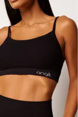 Top deportivo marrón con tecnología seamless, breteles finos y textura con microtramas respirables. Cuenta con forro interno.