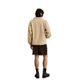 Buzo de polar tipo sherpa en color beige, con cierre frontal parcial y cuello alto. Presenta una banda horizontal estampada con diseño geométrico étnico en tonos marrones y blancos a la altura del pecho.