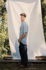 Remera de jersey lavado color azul claro, de corte holgado y cuello redondo, con bordado frontal en color rojo.