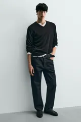 Mocasín de cuero negro, de estilo clásico y minimalista, con suela fina y horma cuadrada.