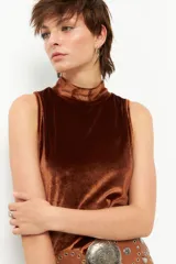 Top de terciopelo marrón, sin mangas y de cuello alto.