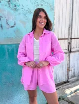 Conjunto de dos piezas compuesto por una camisa de lino con mangas abullonadas y un short a juego con forro interior, ambos en color rosa.