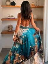 Vestido largo verde con diseño estampado tipo tie-dye y detalles dorados, de corte fluido, un solo hombro y diseño amplio.