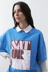 Remera de manga corta con corte boxy fit, color blanco, con estampa frontal geométrica en tonos azul, rosado y marrón.