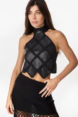 Top halter negro confeccionado con una mezcla de cuero y tejido artesanal, con diseño geométrico de rombos unidos por costuras de crochet y dobladillo en punta.