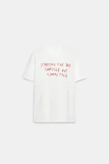 Camiseta blanca de algodón flamé, con cuello redondo, manga corta y estampado frontal de texto en color rojo con la frase 'Starting the day confused but committed'.